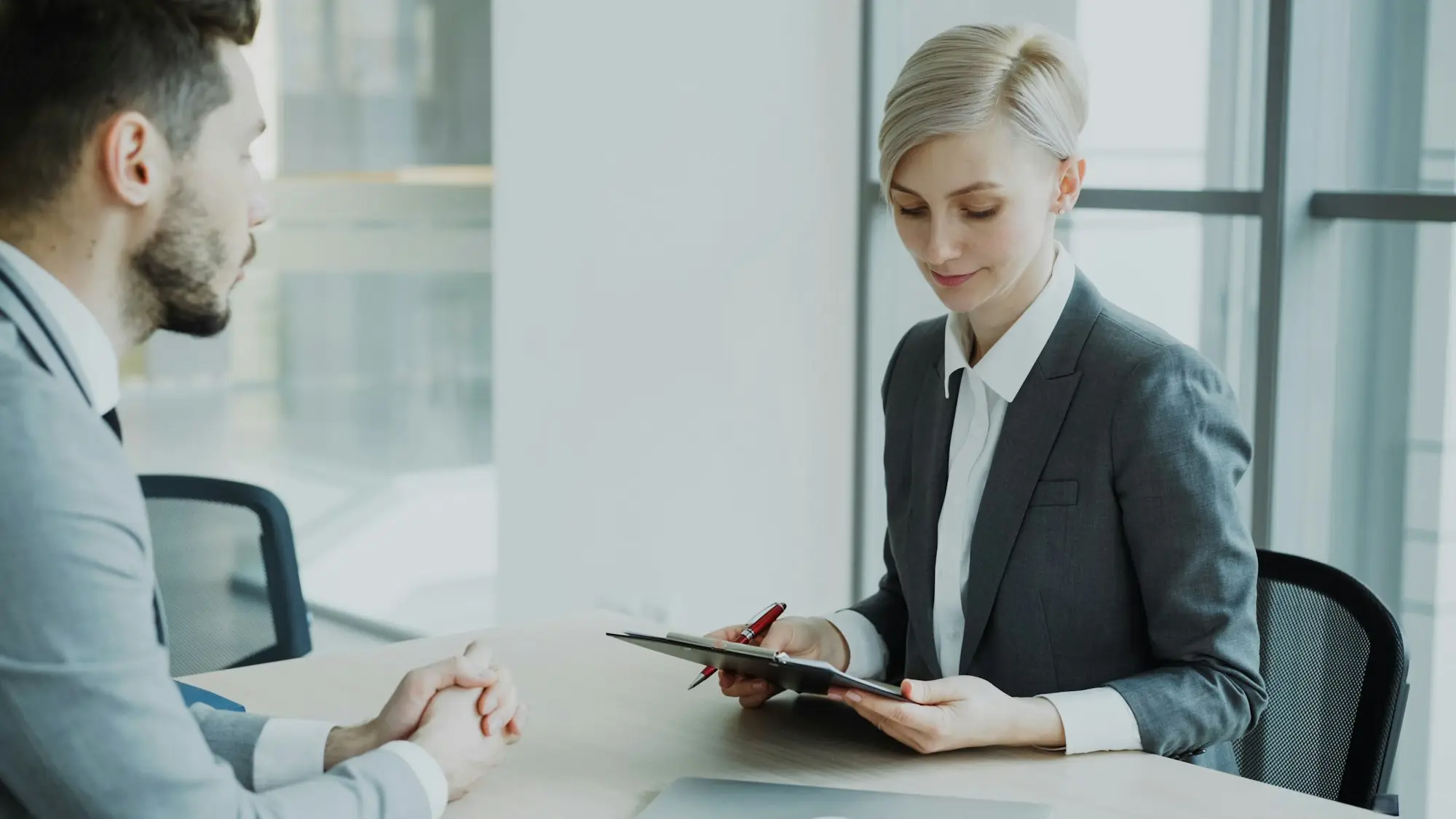 A consultant and a client reviewing a document together at a meeting table in a small office.